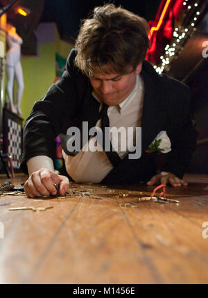 Drunk man on the bar floor, looking for his keys. Stock Photo