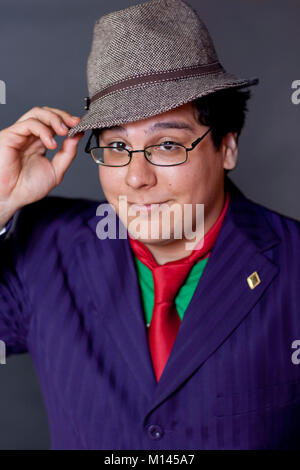 Man in a colorful suit and tie, wearing a fedora hat, and glasses. Stock Photo