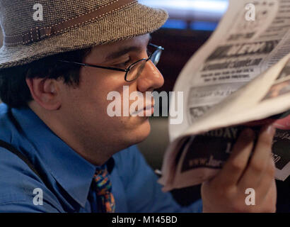 Man in a hat, reading a newspaper. Stock Photo