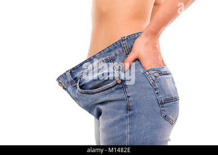 Woman shows that she has lost weight. Big jeans. Stock Photo