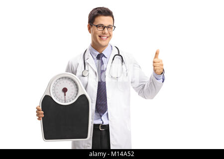 Doctor holding a weight scale and making a thumb up gesture isolated on white background Stock Photo