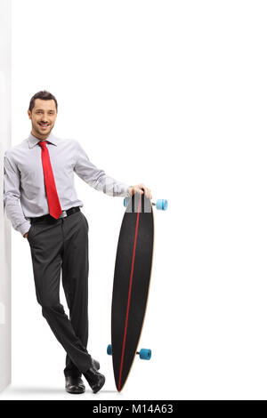 Full length portrait of a businessman with a longboard leaning against a wall isolated on white background Stock Photo