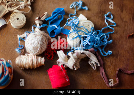 A bunch of colorful red, blue and white old vintage ropes on a brown table. Stock Photo
