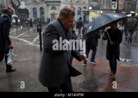 Storm Georgina swept across parts of Britain and in central London, lunchtime office workers were caught out by torrential rain and high winds, on 24th January 2018, in London, England. Pedestrians resorted to leaping across deep puddles at the junction of New Oxford Street and Kingsway at Holborn, the result of overflowing drains. Stock Photo