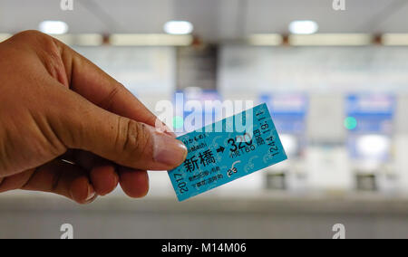 Tokyo, Japan - May 20, 2017. Hand holding a train ticket at the JR station in Tokyo, Japan. Railways are the most important means of passenger transpo