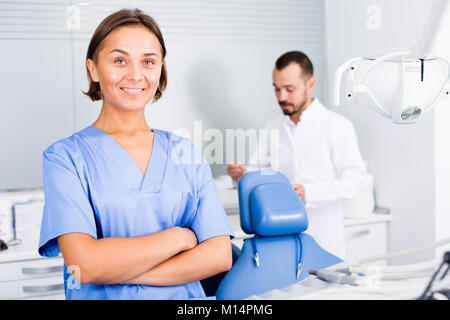 Young doctor with assistant are posing on workplace in hospital Stock Photo
