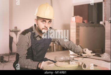 happy american  builder is preparing for repair in the room at object. Stock Photo