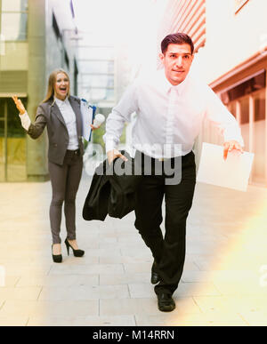 Manager is running away from angry woman boss outdoors. Stock Photo