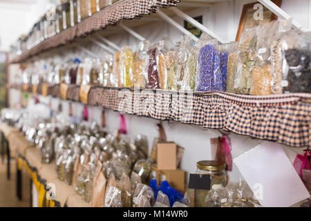 Glass cans with many different dry spices standing on shelf in organic shop Stock Photo