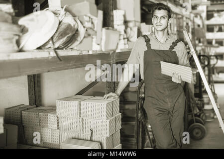 Craftsman is choosing tiles in the building store. Stock Photo