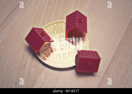 Bitcoin and mini red house on table Stock Photo