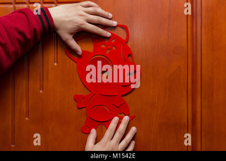 man sticking a Chinese New Year of the Dog 2018 to a door Stock Photo