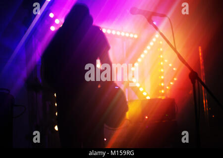 Bright colorful blurred rock music abstract background, bass guitar player on a stage Stock Photo
