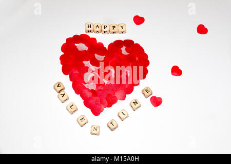 white cubes with black letters beside a bigger red heart made of smaller red hearts on a white background Stock Photo