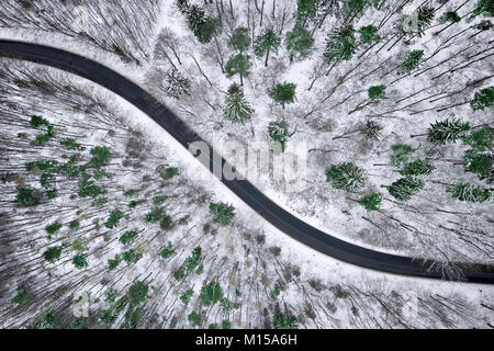 Aerial view of winter road in snowy forest. Drone captured shot from above. Stock Photo