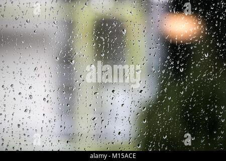 Raindrops on a window pane with out-of-focus background Stock Photo