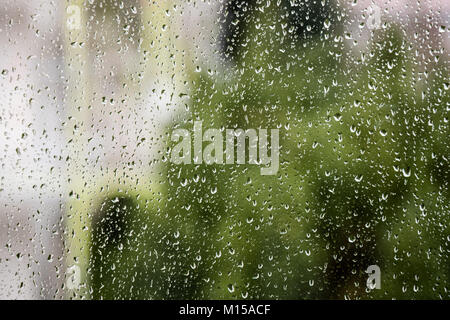 Raindrops on a window pane with out-of-focus background Stock Photo