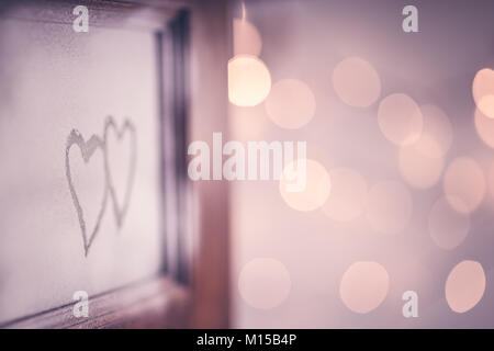 Open doors to love, two hand drawn hearts on the open door, festive blurry bokeh lights background, romantic winter holiday, conceptual photo Stock Photo