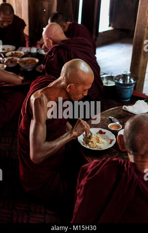 BAGAN, MYANMAR - NOVEMBER, 2016: Monks in a monastery near Mandalay preparing for lunch. Stock Photo