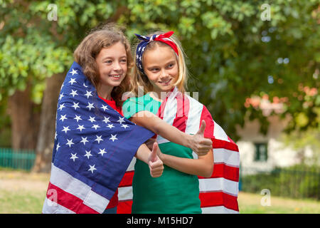 Two girls wrapped in a US flag Stock Photo