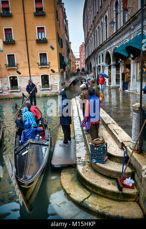 VENICE, ITALY - MAY 20, 2017: Tourists in a Gondola on the canals of Venice near Piazza San Marco. Stock Photo