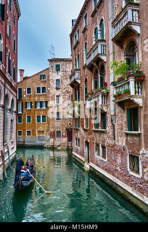 VENICE, ITALY - MAY 20, 2017: This is a view from a bridge, of some beautiful and romantic architecture and canals in the city of Venice, with tourist Stock Photo