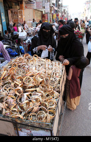 Muslim women wearing NIqab looking at bangles and bracelets Stock Photo