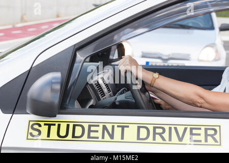 Student driver, with hands on the steering wheel, learning to drive car with driving instructor. Driving school detail Stock Photo