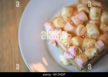 close up home made food photography image of a sweet cake or biscuit snack made with marshmallows white chocolate and peanut butter on a plate