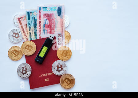 Red passport on a white background, Belarusian rubles with a memory card, digital currency bitcoin, gold coins, cold wallet flash drive. Encrypt passw Stock Photo