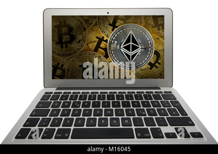Symbol picture cryptocurrency,digital currency,silver coin Ethereum under gold coins Bitcoin on laptop display,cutout Stock Photo