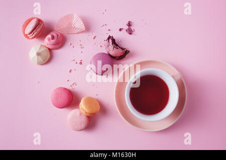 Sweet french macarons and meringues on pink background. Stock Photo