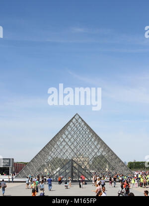 The Louvre Pyramid (Pyramide du Louvre) against blue sky in the main courtyard (Cour Napoleon), Paris, France. Stock Photo