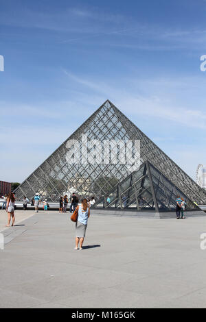 The Louvre Pyramid (Pyramide du Louvre) against blue sky in the main courtyard (Cour Napoleon), Paris, France. Stock Photo