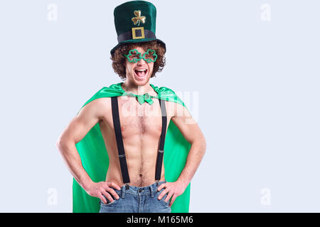 A young curly-haired man in St. Patrick's suit shows his finger  Stock Photo