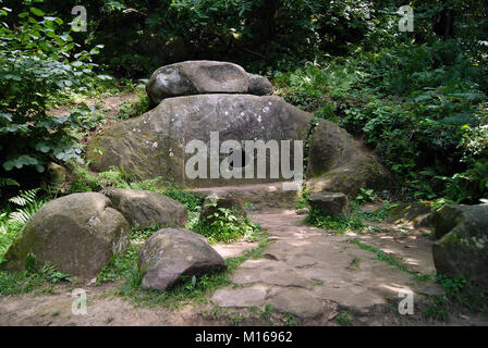 Ancient monolithic dolmen (single-chamber megalithic tomb) with a round hole in the mountain forest of the Caucasus, Russia. Stock Photo