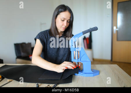Female making belt to order.  Stock Photo