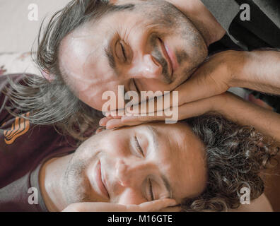 Close up of two Caucasian men pretend sleeping on the couch Stock Photo