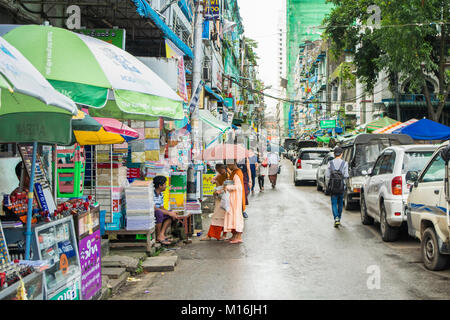 Two boy novice monks, pair of children monks, wearing pink robes, walking in Yangon street collecting daily alms and donations. Burma, Myanmar SE Asia Stock Photo