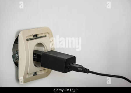 Electrical socket outlet falling out of wall Stock Photo