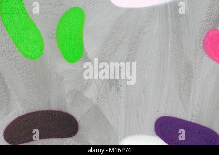 Fragment of graffiti on a flat wall, painted with gray paint. Oval figures of light green, brown and purple colors.  Empty copy space for text. Stock Photo