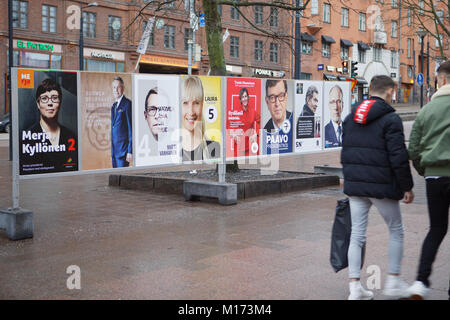 Helsinki, Finland, 27th January, 2018. People on the street at the posters of Presidential candidates . Elections will held tomorrow Credit: StockphotoVideo/Alamy Live News Stock Photo