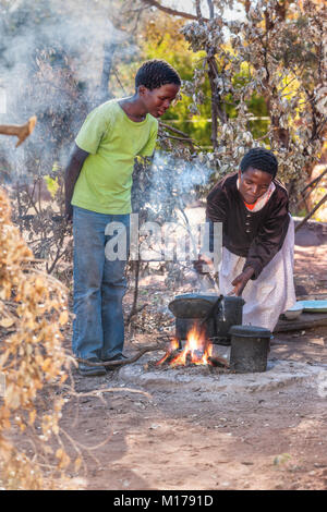 Mom what’s for dinner, African woman cooking outdoors kitchen in the village, Botswana Stock Photo