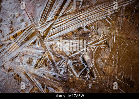 Icy reflections engulf a rock in a New stream during winter. Stock Photo