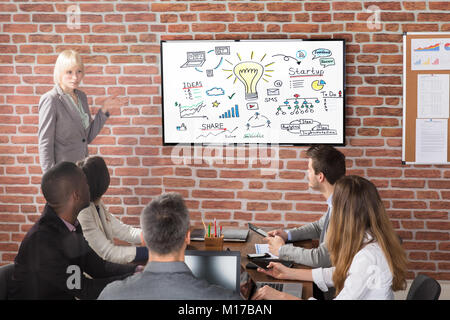 Young Businesswoman Discussing A New Business Project With The Members Of His Team Stock Photo