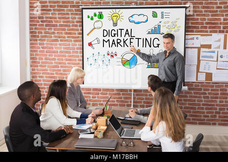 Mature Businessman Giving Digital Marketing Presentation To His Business Team Stock Photo