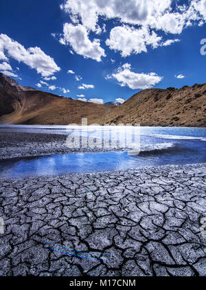 Open cracks due to the dry lake tells a story of how global warming is taking its toll on pristine mother nature Stock Photo