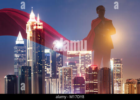 Double Exposure Of Businessman Superhero With Red Cape Dominates The City At Sunset Stock Photo