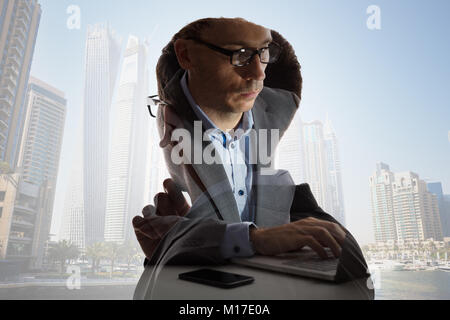 Digital Composite Of Businessman In Suit Working And Buildings In City Stock Photo