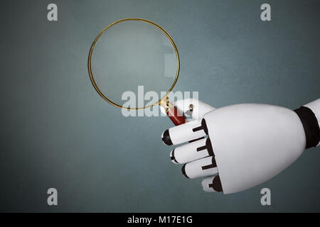 Close-up Of Robot's Hand Holding Magnifying Glass Stock Photo